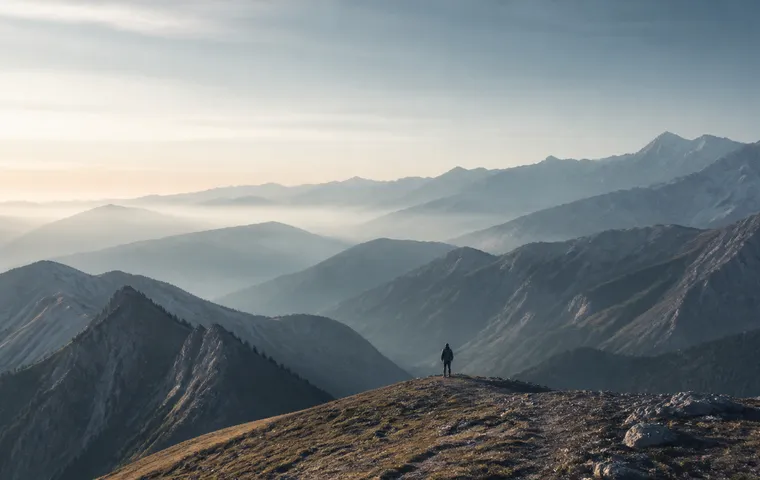 一位旅人站在山脊，远望层叠延伸的山脉。