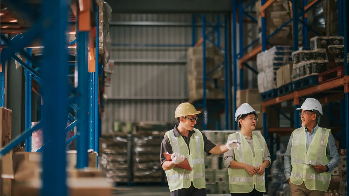 Operators in a warehouse discussing business operations.